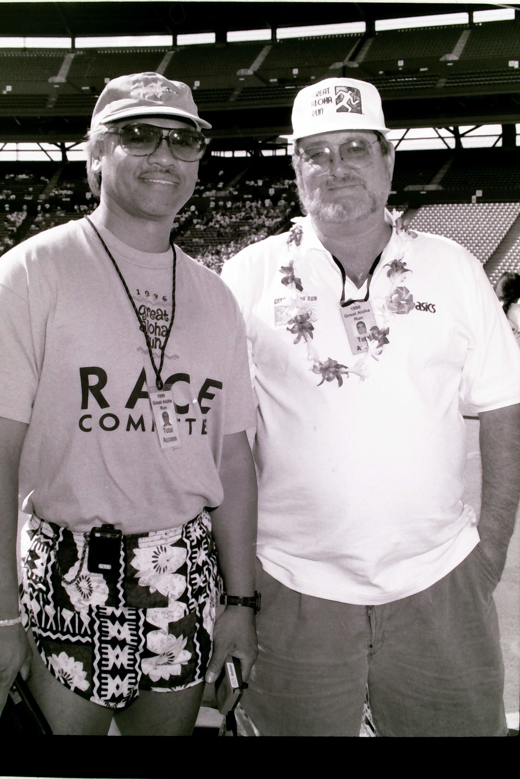 Black and white photo of Alan Sunio and Dr. Jack Scaff, both wearing caps. Seating from Aloha Stadium is behind them.